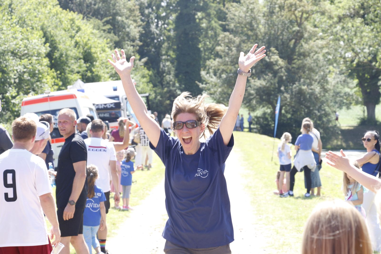 Läuferin jubelt mit erhobenen Armen beim Zieleinlauf des Run for Kids in Klütz
